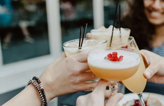 Women cheers with their cocktail drinks together.