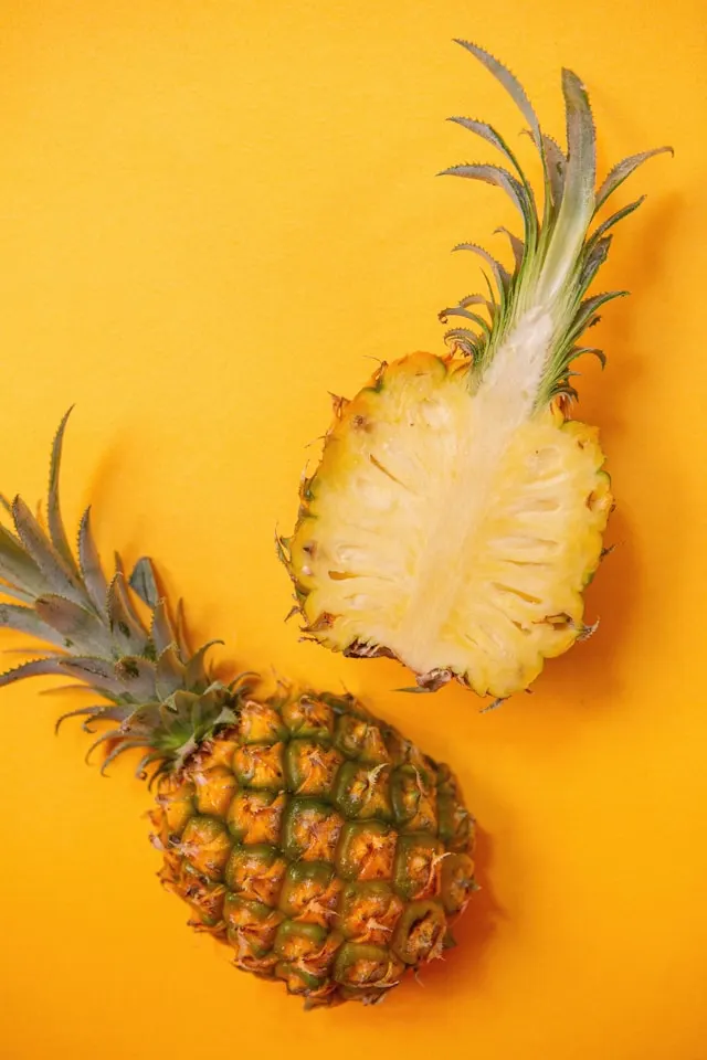 Photo of a fresh and ripe pineapple that has been sliced into two.