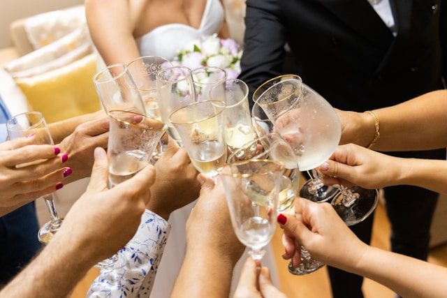 Guests at a wedding and cheers one another with their wine glasses.